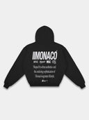 Black Monaco tapered hoodie back mockup with white logo stack, statement graphic and ribbed hem.
