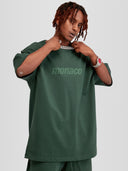 Man model wearing the Tonal Heavyweight Tee in Forest Green with tone-on-tone Monaco Social Club chest print — Monaco Social Club streetwear
