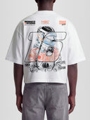 Model wearing the #16 Racing Series Heavyweight Boxy Tee in White with hand-sketched racing driver portrait and MSC Championship badges — Monaco Social Club streetwear