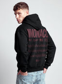 Black Aesthetic hoodie worn by model with burgundy oversized Monaco back graphic and lifestyle typography.