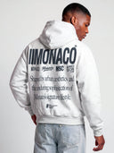Close back view of heather gray athleisure hoodie on model with bold black Monaco branding and oversized text print.