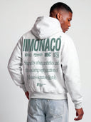 Monaco Aesthetic hoodie in heather gray worn by model, back view with green Monaco branding and statement text.