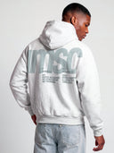 Monaco MSC tapered hoodie in heather gray, angled rear model view with soft sage logo and bold back lettering.
