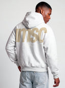 Monaco MSC heather gray hoodie on model, angled back view with oversized beige MSC logo and statement text.