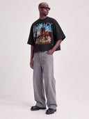 Full-length view of model in Monaco Run Wild black boxy tee with horse graphic and MONACO arch.