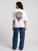 Model in arctic white Untamed oversized tee, back view displaying the large leopard and Monaco graphic.