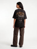 Faded black Untamed raw hem tee worn by model, back view with a large snarling leopard and Monaco text.