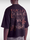 Cropped back view of Monaco Primal Instinct black boxy tee on model, washed leopard graphic.
