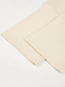 Monaco ivory boxy tee detail: folded sleeve, hem stitching and side seam.