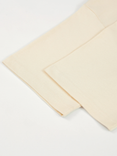 Monaco ivory boxy tee detail: folded sleeve, hem stitching and side seam.
