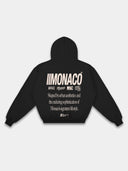 Black Monaco streetwear hoodie back mockup featuring cream branding, statement text and ribbed hem.