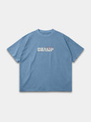 Slate blue Monaco Champ oversized tee, front mockup with cream block lettering, red script and green stars.