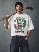 Monaco Social Club Hockey Club: model in a white cropped boxy oversized tee with a retro cartoon hockey front graphic, wooden hockey stick over the shoulder