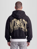 Model wearing The Varsity Heavyweight Full-Zip Hoodie in Black with arched Monaco graphic — Monaco Social Club streetwear