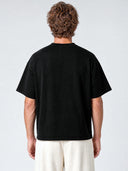 Black Monaco paneled shirt worn by model, back view showing oversized cut and drop shoulders.