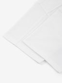White Monaco paneled shirt detail showing sleeve hem and structured panel seam.