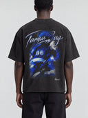 Back view of a model wearing the faded black Monaco Social Club Tampa Bay Blur Tee with blue hockey artwork and a rolled raw hem.